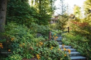 un jardín con flores y escaleras frente a una casa en The Fern Lodge, en Chestertown