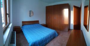 een slaapkamer met een blauw bed en een houten kast bij Agriturismo Vallelunga in Ancona