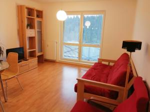 a living room with a red couch and a tv at Apartmán Maruška in Janske Lazne