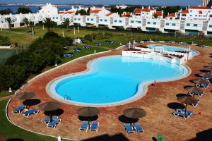 an overhead view of a large swimming pool with umbrellas at Prainha Clube in Alvor