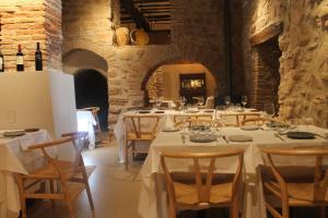 a dining room with white tables and chairs with wine bottles at Posada Ignatius in Navarrete