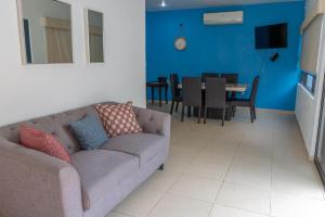 a living room with a couch and a dining room at Apartamentos Torre II Condominios - Pet Friendly in Mazatlán