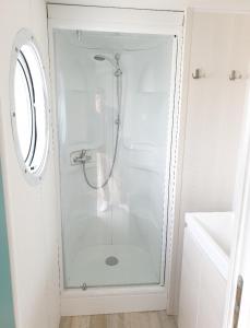 una doccia con una porta in vetro in un bagno di Camping Au Tour de l'Aveyron a LʼHospitalet-du-Larzac