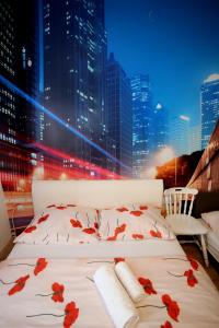 a white bed with red flowers on it in a city at Apartments Rooms FONTANE TRNJE in Zagreb