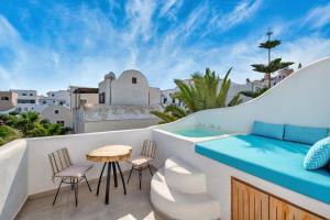 a room with a balcony with a table and chairs at Gianna Suites in Fira