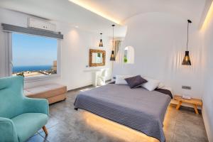 a bedroom with a bed and a chair and a window at Gianna Suites in Fira
