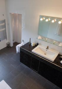 La salle de bains est pourvue d'un grand lavabo et d'un miroir. dans l'établissement Sturmer Hall Hotel and Conference Centre, à Haverhill