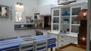 a kitchen with white cabinets and a table with chairs at Blue Ocean in Moliets-et-Maa