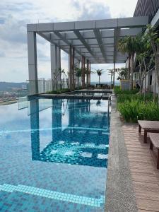 a swimming pool on top of a building at BONJOUR REVO Aurora Place Bukit Jalil in Kuala Lumpur
