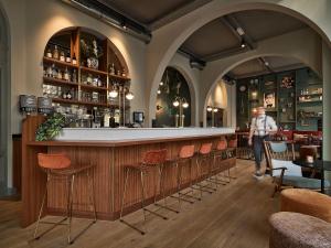 a person standing at a bar in a restaurant at FINCH Boutique Hotel, downtown in Deventer