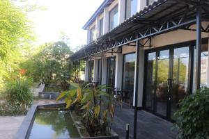 ein Haus mit einem Teich davor in der Unterkunft Chang Palace Vientiane in Vientiane