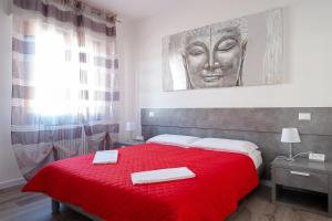 - une chambre avec un lit rouge et 2 serviettes dans l'établissement Residenza Conte Manetti, à Mira