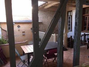 a patio with a table and chairs and a brick building at le patio de l'oustal in Gimont