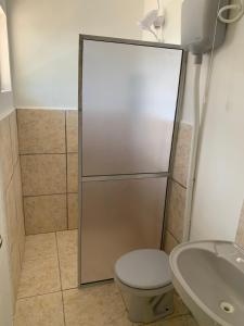 a bathroom with a shower with a toilet and a sink at Ap beira da Praia das Ondinas in São Lourenço do Sul