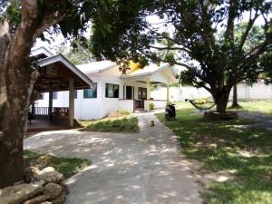 a house with a motorcycle parked in the driveway at Balai Mariacaria Pension House in Guindulman