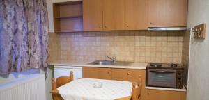 a small kitchen with a table and a sink at Avgi in Kato Loutraki