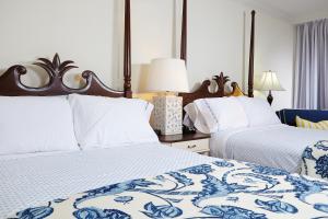 a bedroom with two beds with blue and white sheets at Inn at Pelican Bay in Naples