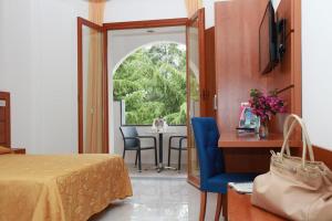 プラーイア・ア・マーレにあるVillaggio Turistico La Mantinera - Hotelのベッドルーム1室(ベッド1台、テーブル、椅子付)