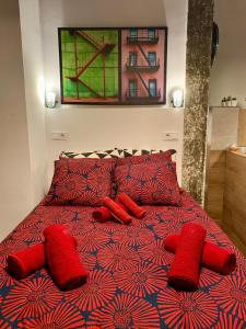 Una cama roja con almohadas rojas encima. en Loft Desing Retiro en Madrid