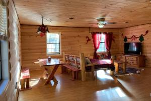 a living room with a table and a tv in a cabin at Wild Reindeer 5min From Parkway HOTTUB FIREpit in Sevierville