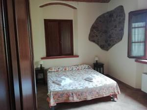 een slaapkamer met een bed, 2 tafels en een raam bij Agriturismo Lupo Vecchio in Grosseto