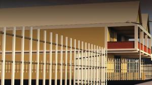 a yellow building with a staircase in front of it at Tropical Villa in Roseau