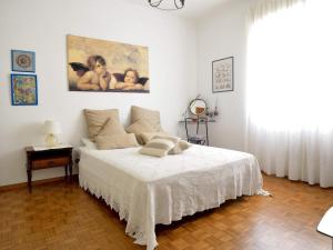 a bedroom with a white bed and a painting on the wall at casa vista mare con wifi, AC nelle 4 camere da letto e parcheggio privato in Imperia