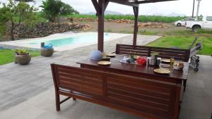 a wooden table with food on it next to a pool at Jag's villa in Plaine Magnien