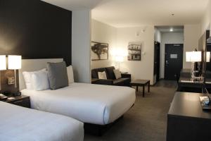 MordenにあるBest Western Plus Mordenのベッド2台とソファが備わるホテルルームです。