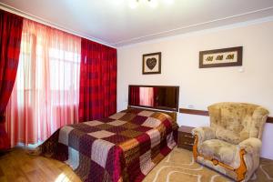 a bedroom with a bed and a chair at Central Park Apartment in the City Center in Kherson
