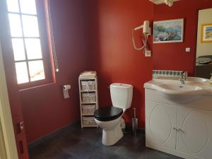 a bathroom with a toilet and a sink at le patio de l'oustal in Gimont