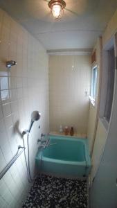 uma casa de banho com uma banheira verde num quarto em Setouchi Triennale Hotel 202 SunMoonStarSeaLight / Vacation STAY 61451 em Takamatsu