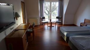 a hotel room with a bed and a flat screen tv at Hotel Heidpark in Lüneburg