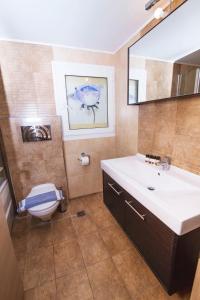 a bathroom with a sink and a toilet and a mirror at Hotel Grand Nefeli in Vasiliki