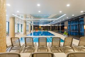 una piscina in un hotel con sedie intorno di FARO Apartamenty Nadmorskie Tarasy SPA przy Latarni free parking pools a Kołobrzeg