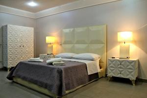 a bedroom with a large bed with two lamps at Donna Teresa in Naples