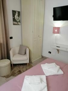 a room with a bed and a chair and a television at Trastevere & Gianicolo Sweet Rest in Rome