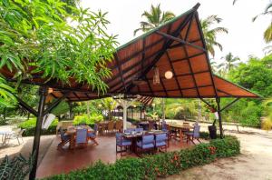 a dining area with tables and chairs under a pavilion at La Mar de Bien Tayrona in Buritaca +144 photos