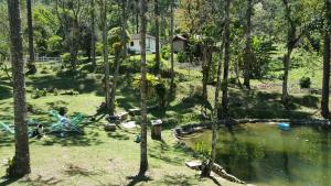 a cabin in the woods with a pond and trees at Gran Camping Cabanas da Fazenda in Visconde De Maua