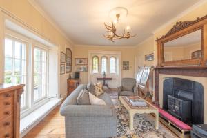 a living room with a fireplace and a tv at Florence Nightingale Suites at Lea Hurst in Highpeak Junction