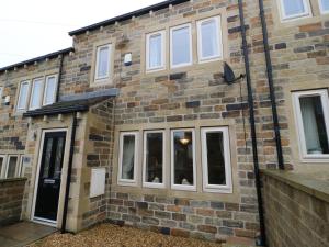 a brick building with white windows and a door at Modern Town House Shepley in Huddersfield