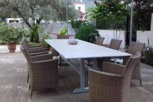 einen Tisch mit Korbstühlen und einen Tisch mit einer Schüssel darauf in der Unterkunft Garden's Home 2 in Leonidi