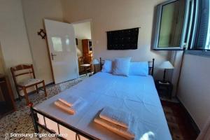 ein Schlafzimmer mit einem großen blauen Bett und einem Tisch in der Unterkunft Garden's Home 2 in Leonidi