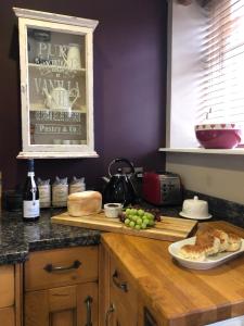 a kitchen with a table with a plate of food and grapes at The Old Dairy - Brosterfield Farm in Eyam