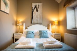 a bedroom with a bed with two pillows on it at The Old Dairy - Brosterfield Farm in Eyam