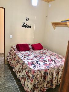 パコチにあるChalé Bela Vista - Chalés Belo Monteのベッドルーム1室(花柄のベッドカバー付)