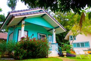 a blue house with a gambrel roof at Cottages @ Hill Resort in Mu Si