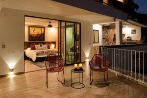 Un balcón con sillas y una cama en un dormitorio. en Villa Bella Bed & Breakfast Inn en Cruz de Huanacaxtle