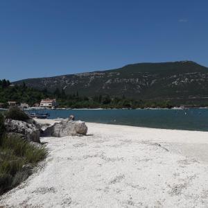 una playa de arena junto a un cuerpo de agua en Apartman I&M, en Ston