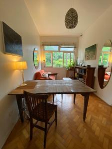 un comedor con una gran mesa de madera y sillas en Vista pro verde, en Río de Janeiro